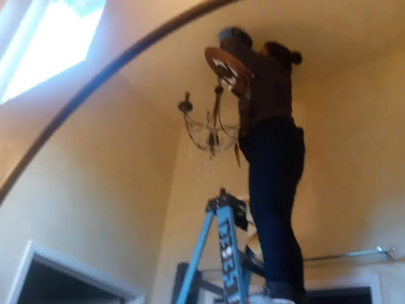 Electrician installing a chandelier in a International Falls residence